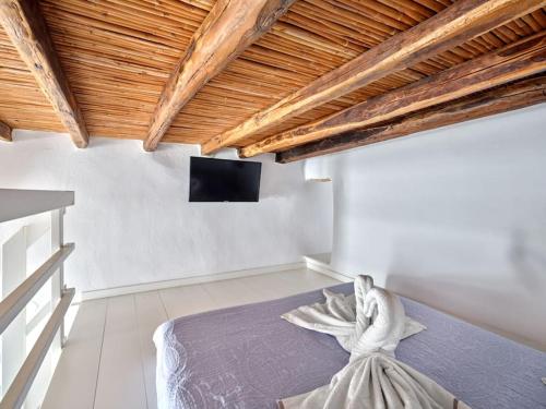 a bedroom with a bed and a flat screen tv at Lindo House in Lefkes