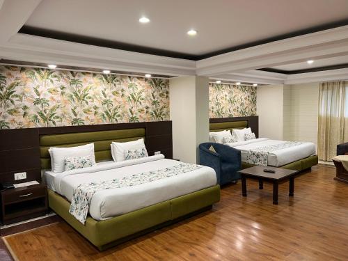 a hotel room with two beds and a couch at Hotel Shiva Continental in Mussoorie