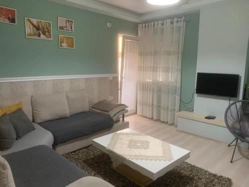 a living room with a couch and a tv at Very nice and romantic apartment in Pogradec