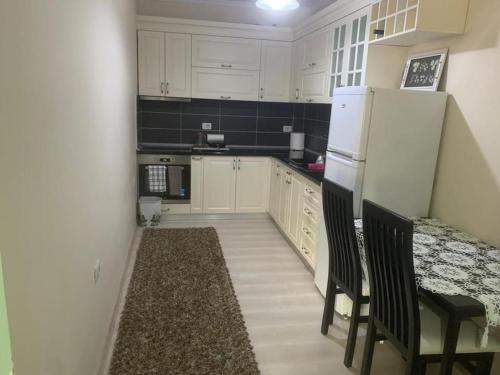 a kitchen with white cabinets and a white refrigerator at Very nice and romantic apartment in Pogradec