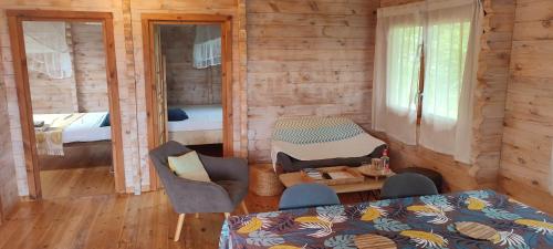 una camera con letto e tavolo e una camera da letto di Bungalow vert corail a Le Vauclin