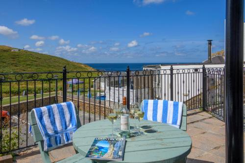 a table and chairs on a balcony with the ocean at Beachcombers Apartments in Newquay