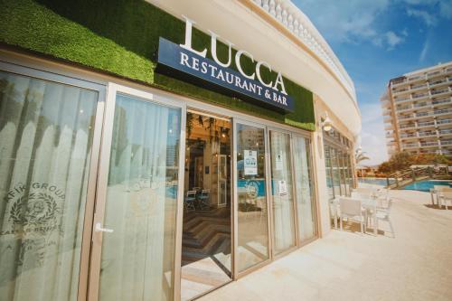a restaurant sign on the side of a building at Amadeus Holiday Apartments in Caesar Resort & SPA, Long Beach in Perivolia tou Trikomou