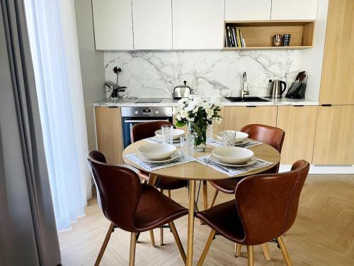 a kitchen with a wooden table with chairs and a dining room at Luxury Designer Suite in Tallinn