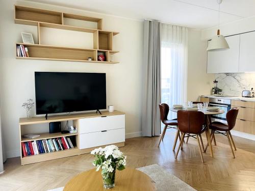 a living room with a television and a table with chairs at Luxury Designer Suite in Tallinn