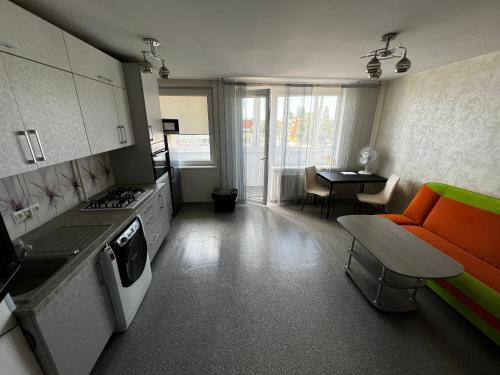 una cucina con un divano arancione e un tavolo di Small Studio Apartament near City Center - self check in a Klaipėda