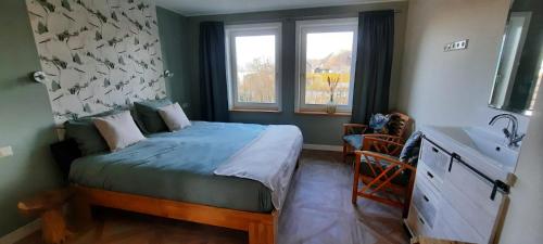1 dormitorio con 1 cama y lavamanos. en B&B de Zilverreiger, en Belt-Schutsloot