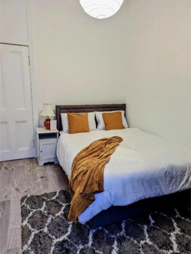 ein Schlafzimmer mit einem Bett mit einer Decke darauf in der Unterkunft Cozy Room Close To The City in Edinburgh
