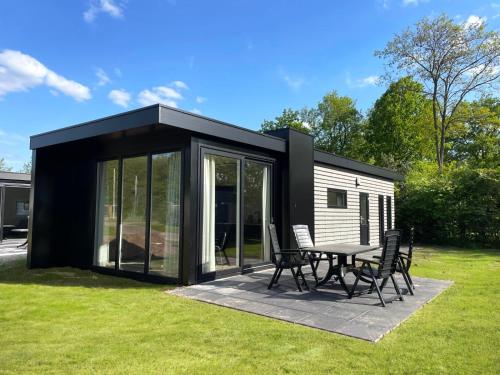 a black and white shed with a table and chairs at Vakantiepark Bronckhorst in Hengelo