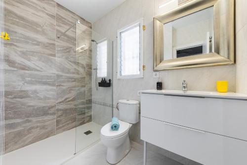 ein Badezimmer mit einem WC, einem Waschbecken und einem Spiegel in der Unterkunft Chalet Villasol Con Piscina in Alicante