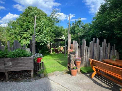 a garden with a wooden fence and a bench at Gasthof Auwirt in Sankt Michael im Lungau
