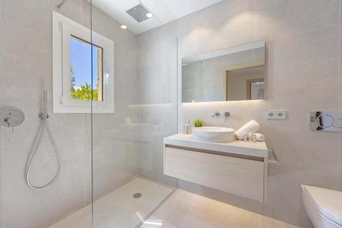 a bathroom with a sink and a glass shower at Cielo de Bonaire in Alcudia