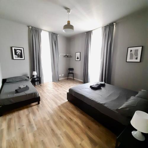 een slaapkamer met 2 bedden en een houten vloer bij Casa Sobit in Turijn