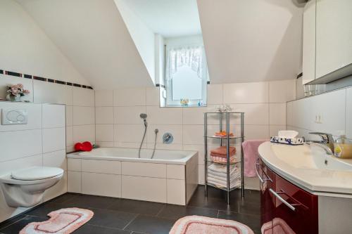 uma casa de banho com uma banheira, um lavatório e um WC. em Storchennest em Markdorf