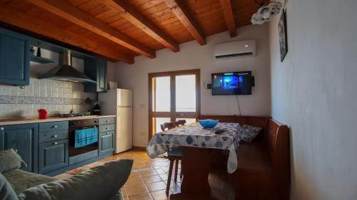 cocina con mesa y TV en la pared en Villa Pinuccia, en Marina di Noto