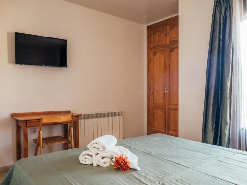 a bedroom with a bed with towels and a television at HOTEL VALMAR in Cuenca