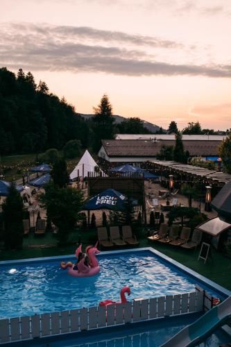 a pool at a resort with two people riding on an inflatable at Hotel Kotarz Spa&Wellness in Brenna