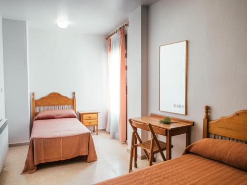 a bedroom with two beds and a table and a desk at HOTEL VALMAR in Cuenca