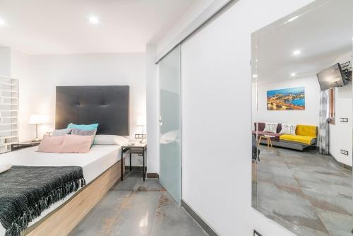 - une chambre avec un lit et un mur en verre dans l'établissement ESTUDIO 10 Junto a La Campana Alameda Setas, à Séville