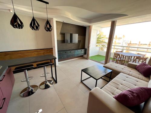 a living room with a couch and a table at The White Waves TF Holiday Apartment Las Americas in Playa Fañabe