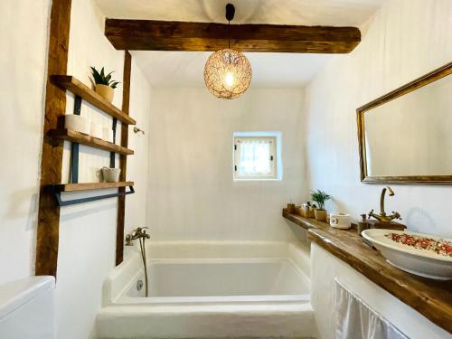 a bathroom with a tub and a sink at Inside, The Village- Rooster's Nest 
