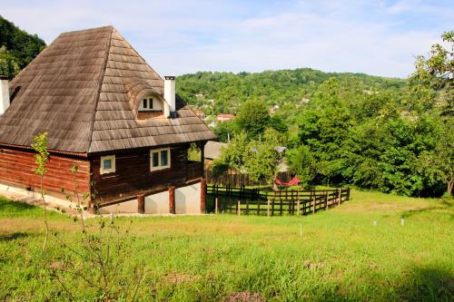 an old barn with a roof on a field at Inside, The Village- Rooster's Nest 