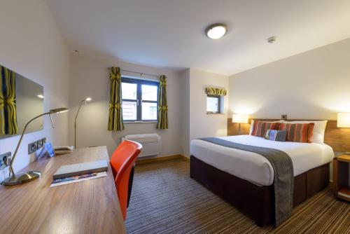 Pokój hotelowy z łóżkiem i biurkiem w obiekcie Cranfield Management Development Centre w mieście Cranfield