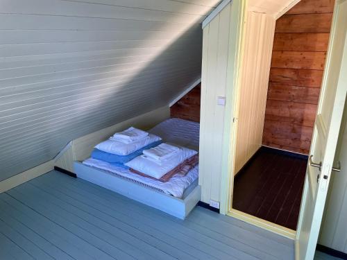 a small room with a bed in the attic at Kræmmervika Rorbuer - Rustic Cabins & Hostel in Lofoten in Ballstad