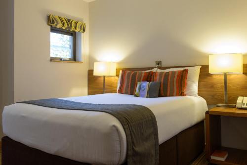 a bedroom with a large bed with two lamps at Cranfield Management Development Centre in Cranfield