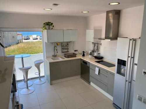 eine Küche mit einem Kühlschrank und einem Tisch darin in der Unterkunft Angeiras Beach House - Porto - Villa by the Sea in Lavra