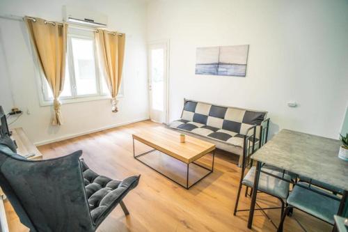 uma sala de estar com um sofá e uma mesa em One bedroom and a patio-Is all about the location! em Tel Aviv