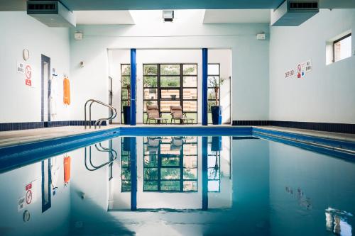 een zwembad met blauw water in een gebouw bij Cranfield Management Development Centre in Cranfield