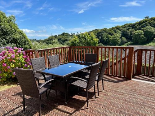 a black table and chairs on a deck at Glen Ard Holiday Home No 1 by Trident Holiday Homes in Dunmore East