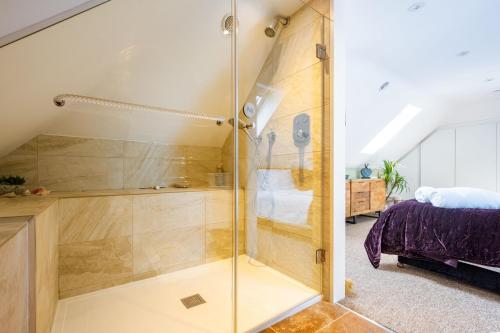 a bathroom with a shower and a bed at At Last in West Beckham