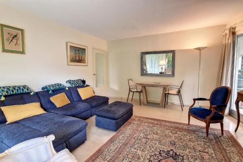 een woonkamer met een blauwe bank en een tafel bij HENRI CAMILLE REAL ESTATE - GOYA - One bedroom close center in Cannes