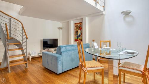een woonkamer met een blauwe bank en een glazen tafel bij Italianway - Paisiello 4 B in Milaan