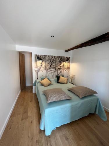 - une chambre avec un lit bleu et 2 oreillers dans l'établissement LE NID DU CHARMANT, à Montagne