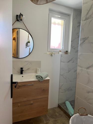 une salle de bain avec un lavabo et un miroir dans l'établissement LE NID DU CHARMANT, à Montagne