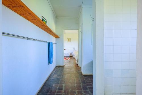a bathroom with a walk in shower and a tiled hallway at The Old Mushroom Farm in Howick
