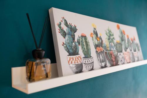 een plank met een hoop cactussen en een foto bij Residenza della Laguna in Orbetello