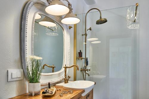 W łazience znajduje się umywalka i lustro. w obiekcie Aqua Mykonos Suites - Adults Only w mieście Tourlos