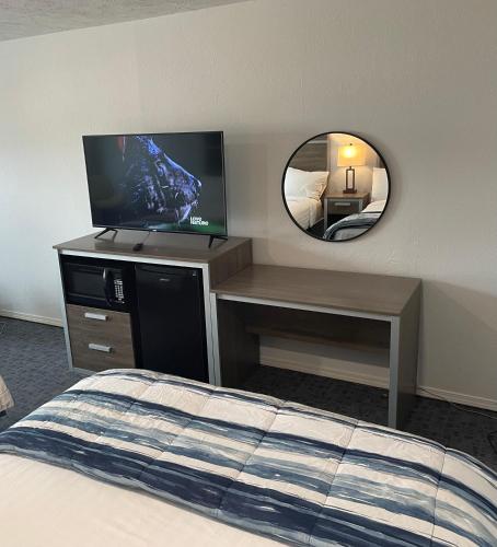 a bedroom with a bed and a tv and a mirror at Americas Best Value Inn Polson in Polson