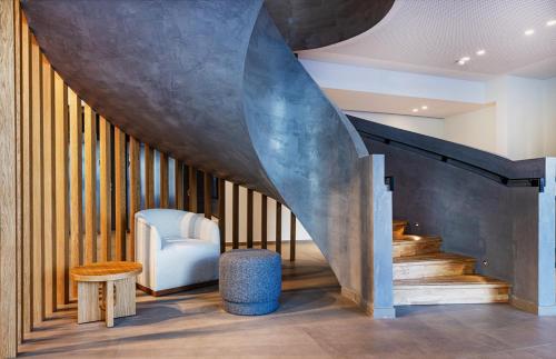 a living room with a staircase with a blue chair at Crowne Plaza - Marseille Le Dôme in Marseille