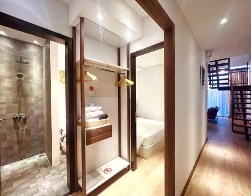 a bathroom with a shower and a door leading to a bedroom at Oxy suites 2-02 at Shop House Meisterstadt Pollux Habibie in Batam Center