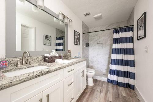 a bathroom with two sinks and a shower at Daytona Buy! Mins from Beaches, Speedway, Airport in Daytona Beach