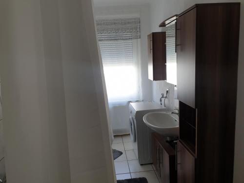ein Bad mit einem Waschbecken, einem WC und einem Fenster in der Unterkunft Gästewohnung in Pirmasens