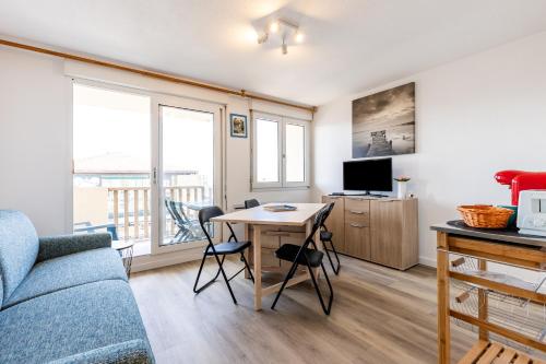 a living room with a couch and a table at 2 pièces face océan, Lacanau in Lacanau