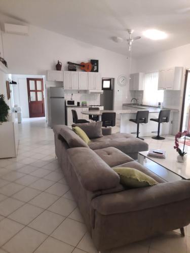 a living room with a couch and a kitchen at Modern Croatian House in Pula