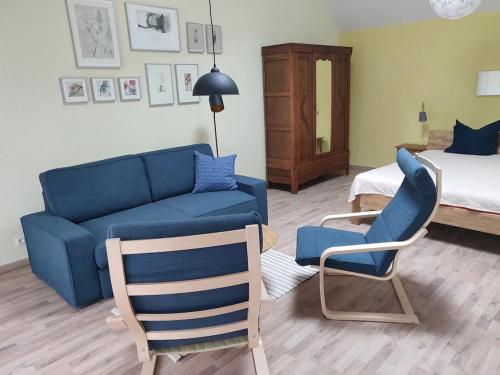 uma sala de estar com um sofá azul e duas cadeiras em Lincoln-Loft Weimar em Weimar