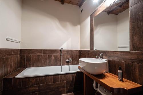 a bathroom with a sink and a bath tub at Alpine Forest Hotel in Champoluc